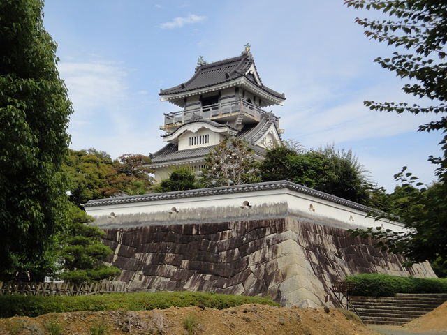 高い石垣と白い塀の上に建つ3層の小山城