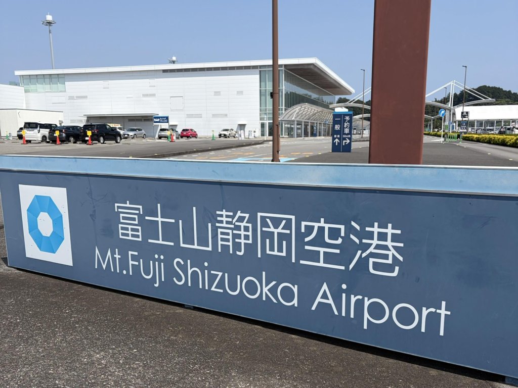 富士山静岡空港の日本語と英語の看板と、その奥のターミナル