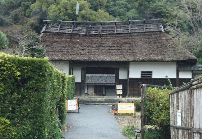 大鐘家の茅葺き屋根の長屋門と入口の小道