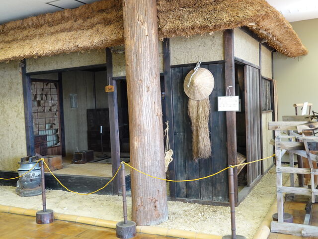 館内に再現された茅葺き屋根の民家と生活道具