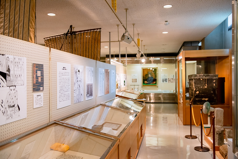 肖像画や解説パネル、展示ケースが並ぶ展示室
