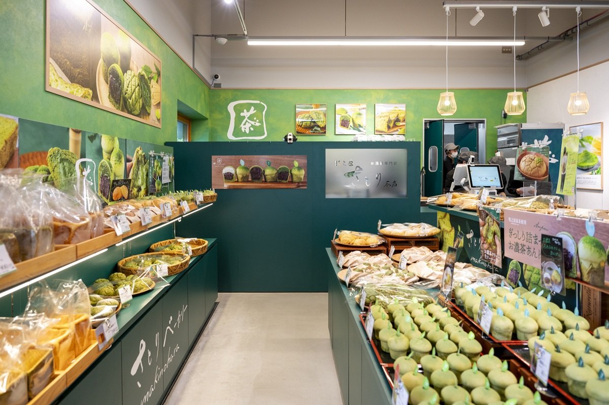 緑の壁の店内に抹茶のパンやマフィンが並ぶベーカリー
