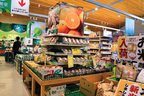 木の棚に椎茸やみかん、新米などが並ぶ農産物の売り場